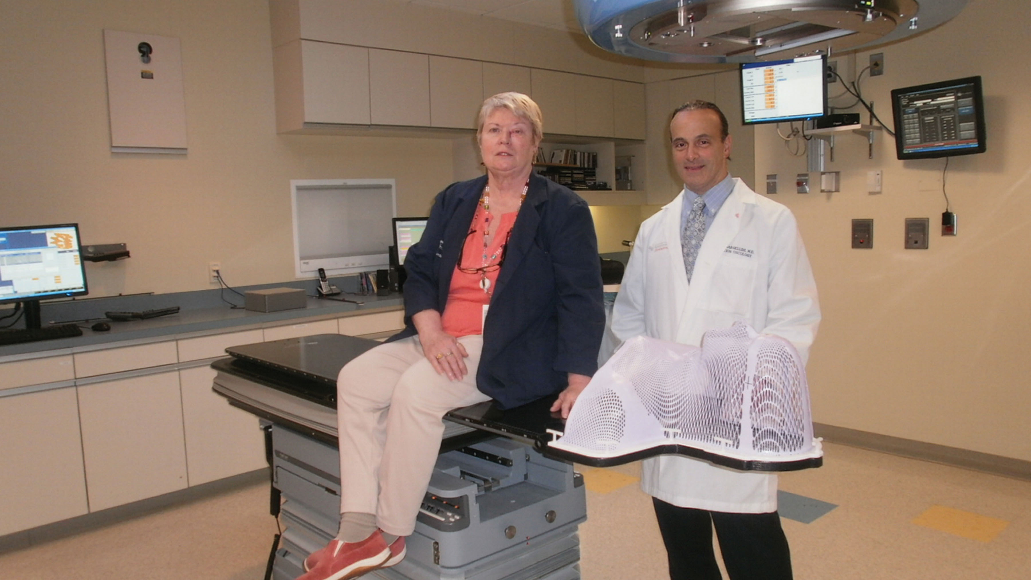 Protura机器人病人定位系统提供的高精确度使癌症患者凯西·凯利的治疗完全不同，如图所示，她和她的医生约瑟夫·巴格里尼。